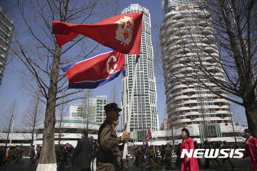 【평양=AP/뉴시스】13일 북한 평양 에서 려명거리 준공식이 열렸다. 사진은 군인들이 인공기 등을 들고 걸어가는 모습. 2017.04.13 