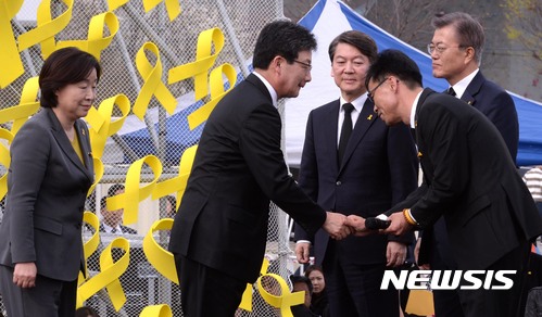 【안산=뉴시스】강종민 기자 = 16일 세월호 3주기 기억식이 열린 안산 세월호 희생자 합동분향소에서 대선 후보들이 추모사를 통해 밝힌 약속을 지키겠다는 의미로 무대에 올라 손을 맞잡았다.&nbsp; 정명선 4.16 세월호 참사 가족협의회 운영위원장이 대선 후보들을 무대에서 맞이하고 있다. 2017.04.16.&nbsp; photo@newsis.com