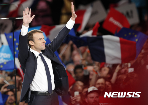 【파리=AP/뉴시스】프랑스 대통령선거 유력주자 에마뉘엘 마크롱) 전 경제장관이 17일(현지시간) 파리에서 한 선거유세전에서 지지층들에게 양손을 들어 인사하고 있다. 그는 이날 고립주의를 주장하는 다른 극우와 극좌 대선 후보들과 달리 열린 프랑스의 대표가 되겠다고 밝혔다. 2017.04.18 