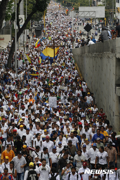【카라카스( 베네수엘라) = AP/뉴시스】 = 베네수엘라의 시위가 3주일째 이어지면서 22일에는 그 동안 총격으로 숨진 시위대와 구경군등 희생자 20명을 추모하기 위한 침묵 대행진이 벌어졌다. 이들은 추모 미사가 예정된 기독교회관까지 진출했고 주로 부유층 지역에서만 이뤄지던 시위가 처음으로 그 동안 접근하지 못했던 빈민가의 '베를린 장벽'을 넘었다. 