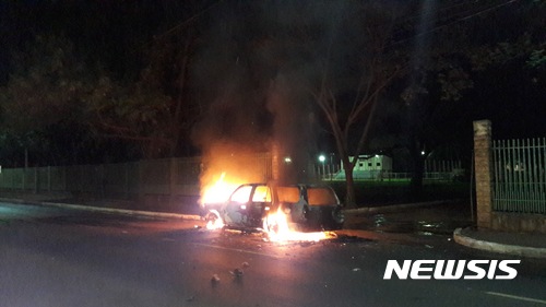 【아순시온(파라과이) = AP/뉴시스】 = 24일 발생한 파라과이 국경의 대규모 무장강도사건으로 불타고 있는 차량. 소총과 폭탄으로 무장한 80명의 강도들은 이 날 브라질, 아르헨티나와의 3국 접경지대인 치우다드 델 에스테에 있는 방탄차 제조회사 건물을 습격, 금고를 폭파하고 현금을 털어 브라질 쪽으로 달아났다고 경찰은 말했다.