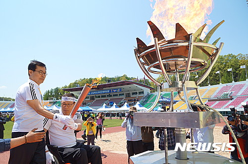 【안동=뉴시스】김진호 기자 = 27일 경북 안동시민운동장에서 열린 제19회 경상북도장애인체육대회에서 성화 봉송 최종주자로 나선 김성진 안동시의회 의장과 홍성직 안동시 장애인탁구협회장이 성화대에 점화하고 있다.2017.04.27   kjh9326@newsis.com