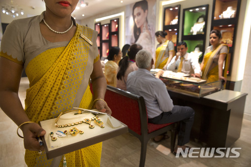 【뉴델리=AP/뉴시스】인도 뉴델리의 한 보석가게에서 직원이 금으로 된 장신구를 선보이고 있다. 사진은 지난 4월 27일 힌두교 축제인 '아크샤이 티리티야' 기간에 촬영됐다. 인도인들은 이 기간 금을 지니고 있으면 행운이 찾아온다고 여긴다. 2017.11.21
