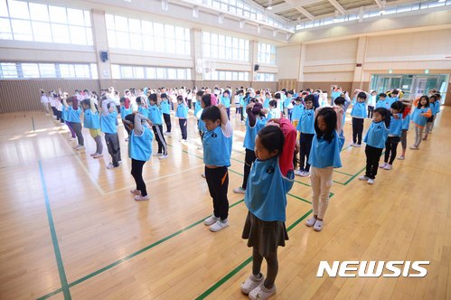 【서울=뉴시스】전신 기자 = 1일 서울 서초구 우솔초등학교에서 열린 어린이날 맞이 체육대회에서 학생들이 몸풀기 체조를 하고 있다. 이날 체육대회는 미세먼지 영향으로 실내에서 진행됐다. 2017.05.01.   photo1006@newsis.com 