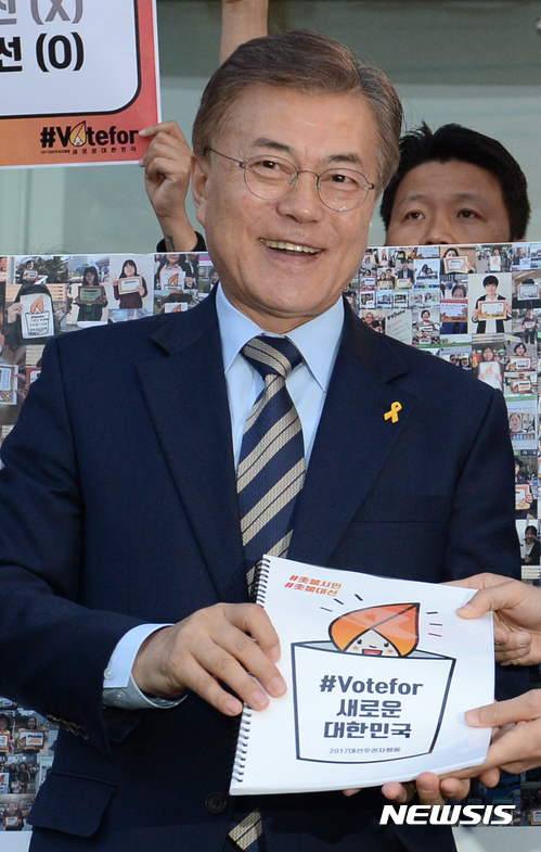 【서울=뉴시스】임태훈 기자 = 문재인 더불어민주당 대선후보가 2일 오후 서울 마포구 상암MBC 경영센터 앞에서 대선주권자행동 주최로 열린 '새로운 대한민국 vote for 시민인증샷' 전달식에서 인증샷 책자를 받고 있다. 2017.05.02.&nbsp; taehoonlim@newsis.com