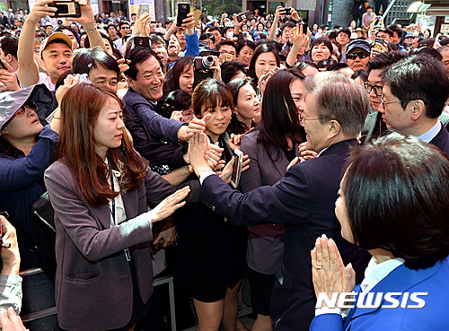 【서울=뉴시스】박영태 기자 = 3일 오전 서울 종로구 조계사에서 진행된 ‘부처님 오신 날 봉축 법요식’에 참석한 문재인 더불어민주당 대선후보가 행사가 끝나고 퇴장하며 시민들의 손을 잡고 있다 2017.05.03.&nbsp; since1999@newsis.com