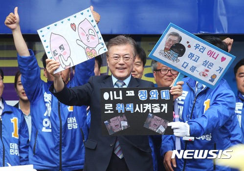 【포항=뉴시스】홍효식 기자 = 문재인 더불어민주당 대선후보가 5일 오후 경북 포항시 북구 중앙상가길에서 열린 유세에서 응원문구가 적힌 피켓을 들고 있다. 2017.05.05.&nbsp;&nbsp; photo@newsis.com