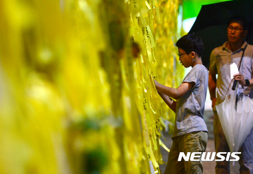 【목포=뉴시스】임태훈 기자 = 수중 수색 중 세월호 침몰해역에서 사람 뼈로 추정되는 유해가 발견된 5일 오후 세월호가 거치된 전남 목포신항에서 한 어린이가 노란 리본을 달고 있다. 2017.05.05. taehoonlim@newsis.com