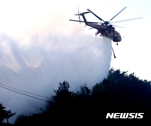 【강릉=뉴시스】김경목 기자 = 7일 오전 산림청 산불 진화 헬기에서 강원 강릉시 성산면 보광리 일대 올림픽철도 공사 현장 야산에 번지고 있는 산불을 끄기 위해 대량의 물을 투하하고 있다. 2017.05.07.&nbsp; photo31@newsis.com