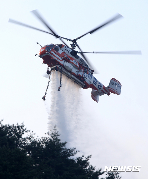 【강릉=뉴시스】김경목 기자 = 7일 오전 산림청 산불 진화 헬기에서 강원 강릉시 성산면 보광리 일대 올림픽철도 공사 현장 야산에 번지고 있는 산불을 끄기 위해 대량의 물을 투하하고 있다. 2017.05.07.&nbsp; photo31@newsis.com