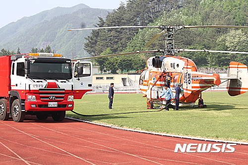  【삼척=뉴시스】 김태식 기자 = 7일 강원 삼척시 도계읍 점리 야산의 산불이 강풍을 타고 이틀째 확산되고 있는 가운데 도계공설운동장에서 진화 헬기가 급유를 하고 있다. 2017.05.07&nbsp; newsenv@newsis.com