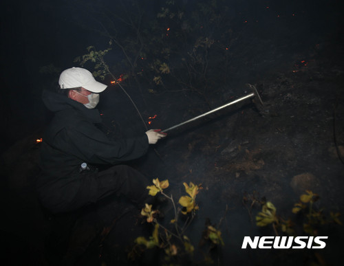 【강릉=뉴시스】김경목 기자 = 8일 새벽 강원 강릉시청 공무원이 강릉시 성산면 어흘리 대관령 길목의 백두대간 야산에서 전날 꺼졌던 산불이 초속 20m 이상의 강한 바람을 타고 재발해 번지자 방어선을 구축하고 있다. 2017.05.07. photo31@newsis.com