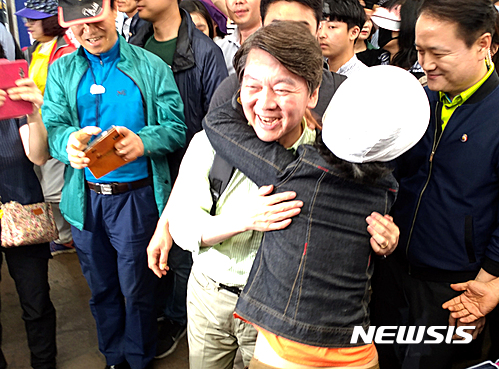 【천안=뉴시스】이종익 기자 = 안철수 국민의당 대선후보가 선거유세 마지막날인 8일 오후 충남 천안시 동남구 남산중앙시장을 방문한 가운데 한 여성 시민으로부터 기습 포옹을 당하고 있다. 2017.05.08&nbsp;&nbsp; 007news@newsis.com