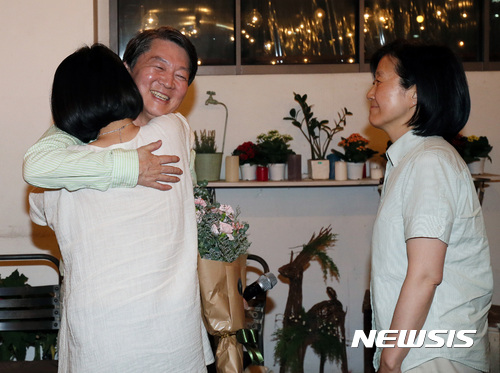 【서울=뉴시스】강종민 기자 = 안철수 국민의당 대선 후보가 8일 밤 서울 마포구 홍대 한 카페에서 열린 페이스북라이브 오픈스튜디오에서 부인인 김미경 교수와 딸 설희씨와 포옹을 하고 있다. 2017.05.08.&nbsp; photo@newsis.com 
