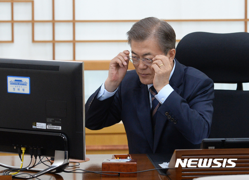 【서울=뉴시스】전진환 기자 = 문재인 대통령이 12일 오후 청와대 여민관 집무실에서 제37주년 5·18기념식 임을 위한 행진곡 제창과 국정교과서 정상화업무지시 전자서명을 위해 안경을 끼고 있다. 2017.05.12.&nbsp; amin2@newsis.com