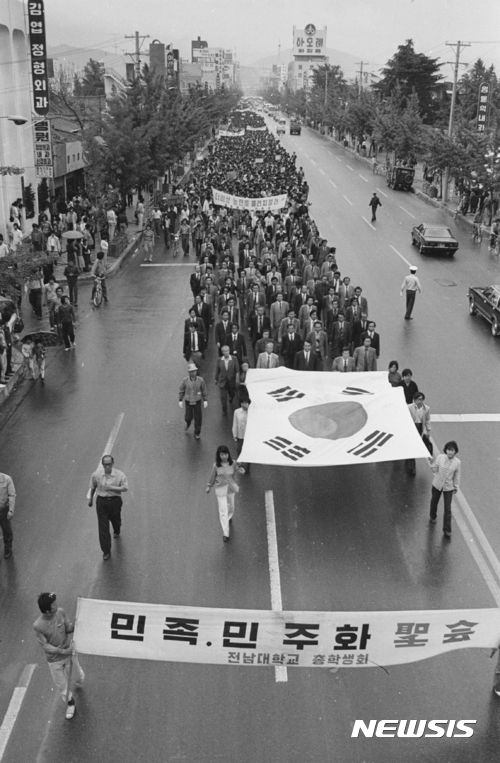 【광주=뉴시스】 = 오는 17일 광주 동구 옛 전남도청 앞에서는 5·18민주화운동아 38주기 전야제가 펼쳐진다. 사진은 1980년 5월 광주지역 대학교 교수와 학생들이 민족민주화성회 집회를 위해 태극기를 앞세우고 질서정연하게 가두행진을 하는 모습. 2018.05.07. (사진=5·18기념재단 제공) photo@newsis.com