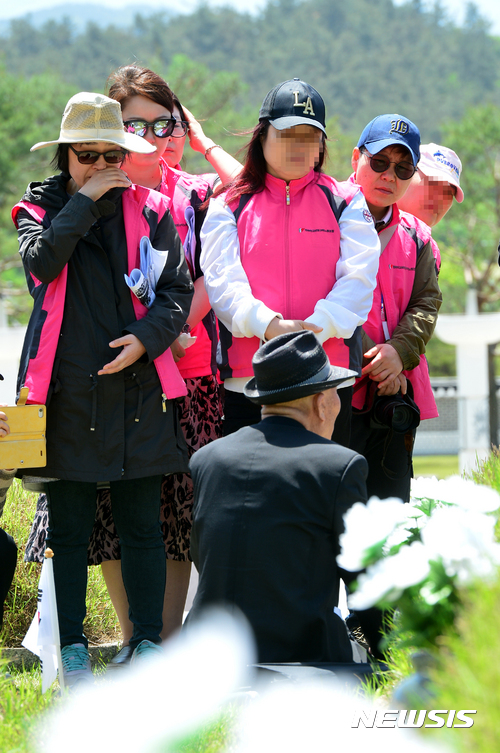 【광주=뉴시스】배동민 기자 = 제37주년 5·18기념식을 나흘 앞둔 14일 오전 광주 북구 운정동 국립5·18민주묘지에 5월 영령들의 뜻을 잇기 위한 추모객들의 발길이 이어졌다. 추모객들이 1980년 5월27일 전남도청에서 광주시민을 지키려다 사망한 문재학(당시 17세·고1) 열사의 아버지 문건양씨로부터 그날을 진실을 들으며 눈물을 흘리고 있다. 2017.05.14. guggy@newsis.com