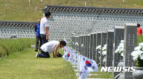 【광주=뉴시스】배동민 기자 = 제37주년 5·18기념식을 나흘 앞둔 14일 오전 광주 북구 운정동 국립5·18민주묘지에 5월 영령들의 뜻을 잇기 위한 추모객들의 발길이 이어졌다. 1980년 5월 계엄군에게 살해된 허봉(당시 23세·이발소 종업원)씨의 유가족이 묘역에서 큰절을 하고 있다. 2017.05.14. guggy@newsis.com