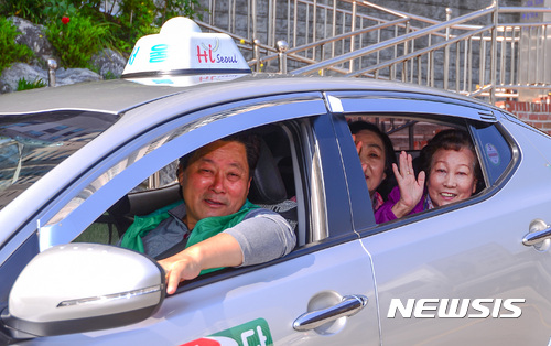 【서울=뉴시스】김선웅 기자 = 17일 오전 서울 성북구 정릉1동 주민센터 앞에서 정릉1동 택시기사들의 차량에 탑승한 성북구 관내 독거 어르신들이 임진각 나들이 출발에 앞서 손을 흔들고 있다. 2017.05.17. mangusta@newsis.com