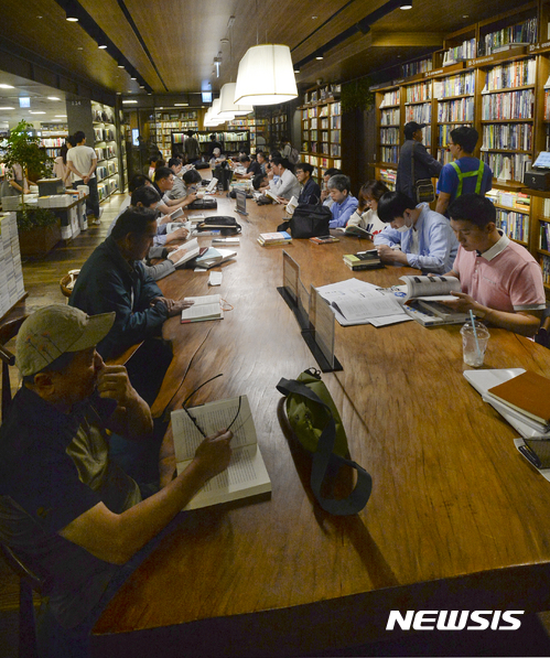 【서울=뉴시스】최진석 기자 = 초여름 무더위가 찾아온 19일 오후 서울 한 서점을 찾은 고객들이 더위를 피해 자리에 앉아 책을 읽으며 휴식을 취하고 있다. 2017.05.19. myjs@newsis.com