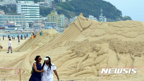 【부산=뉴시스】 하경민 기자 = 지난 21일 부산 해운대해수욕장 백사장에 더위를 식히러 나온 시민들과 관광객들이 모래조각 작품을 감상하며 지나가고 있다.   2017.05.21.  yulnetphoto@newsis.com