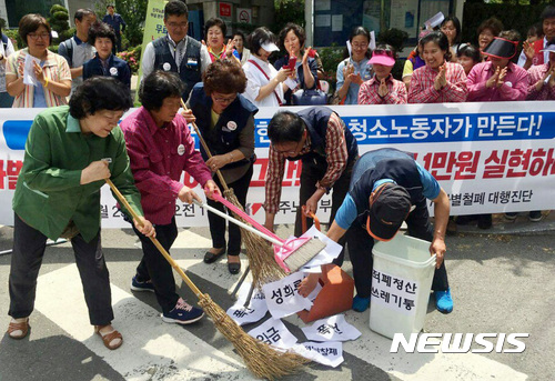 【부산=뉴시스】하경민 기자 = 23일 부산 연제구 부산고용노동청 앞에서 부산지역 청소노동자들이 차별 철폐와 처우 개선, 최저임금 1만원 실현 등을 요구하는 기자회견을 가진 뒤 막말, 폭언, 성희롱 등을 참고 견디는 청소노동자를 쓰레기 취급하는 이 사회를 청소하겠다는 뜻으로 퍼포먼스를 펼치고 있다. 2017.05.23. (사진=민주노총 부산본부 제공)   yulnetphoto@newsis.com