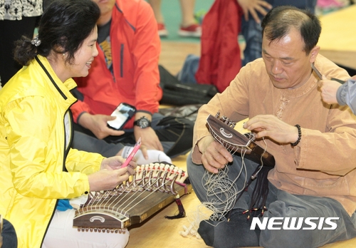 【영동=뉴시스】이성기 기자 = 국악의 감성과 향기가 가득한 '10회 대한민국 국악기 제작체험 축제'가 오는 27~28일 이틀간 충북 영동 국악체험촌 일원에서 열린다. 사진은 이 행사를 주관하는 난계국악기제작촌 관계자가 관람객의 국악기 제작 체험을 돕고 있는 모습이다.2017.05.25(사진=영동군 제공)   sklee@newsis.com 