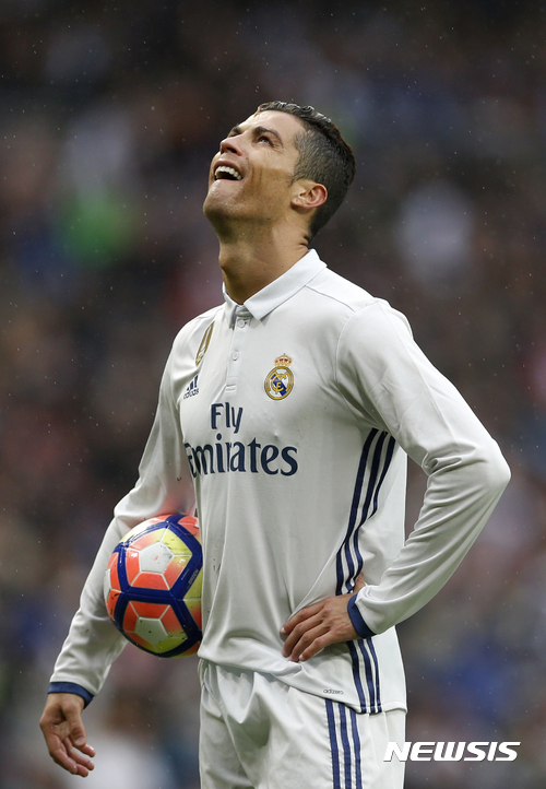 FILE - In this April 29, 2017, file photo, Real Madrid's Cristiano Ronaldo looks up during a Spanish La Liga soccer match between Real Madrid and Valencia at the Santiago Bernabeu stadium in Madrid, Spain. Spanish prosecutors said Thursday, May 25, 2017 that they are considering whether Ronaldo should face charges over allegations by the country's tax agency that he defrauded the authorities of 15 million euros ($16.7 million) between 2011 and 2014. (AP Photo/Francisco Seco, File)