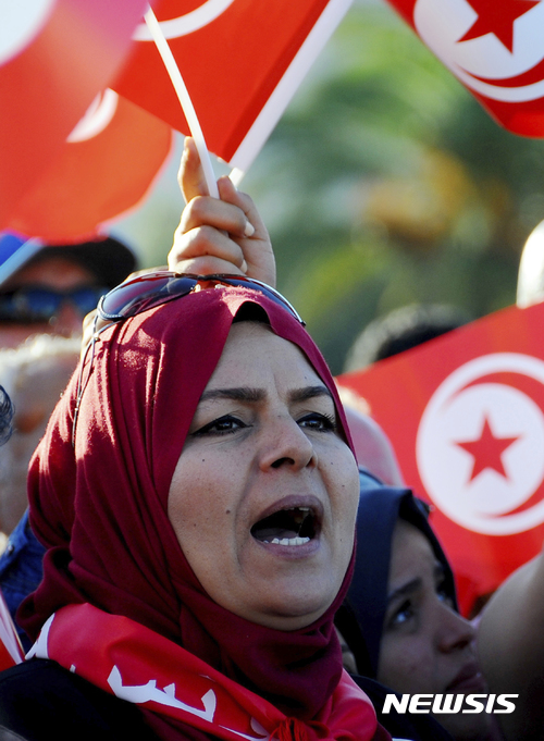 【튀니스=AP/뉴시스】튀니지 의회에서 여성에 대한 모든 폭력을 금지하는 법안이 26일(현지시간) 통과됐다. 내년부터 발효되는 새 법안은 여성에 대한 폭력을 "남녀 간의 차별에 근거한  공공 및 사생활에서의 신체적/도덕적/성적 및 경제적 침략과 이에 대한 위협"으로 정의하고 피해자 구제 방안 등을 규정한다. 사진은 지난 5월26일 부패 혐의로 8대 기업인의 자산을 동결한 튀니지 정부에 대한 지지 집회에 나선 여성의 모습. 2017.07.27