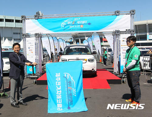 【제주=뉴시스】우장호 기자 = 원희룡 제주특별자치도지사가 27일 오전 제주시 오라1동 종합경기장 특별행사장 일원에서 열린 제4회 제주 전기차 에코랠리 대회에 참석해 출발을 알리는 깃발을 들고 있다. 2017.05.27. woo1223@newsis.com