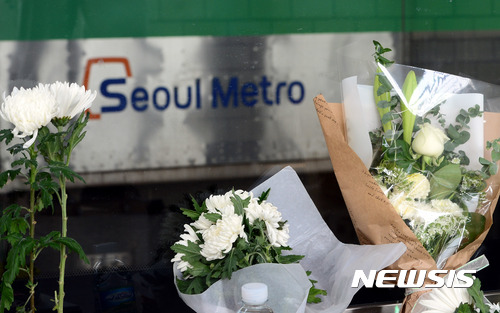 【서울=뉴시스】임태훈 기자 = 지하철 2호선 구의역 스크린 도어 사고 1주기인 28일 오후 서울 광진구 구의역 강변역 방면 9-4 승강장 앞에 희생자 김군을 추모하는 시민들이 두고간 국화꽃이 놓여있다. 2017.05.28. taehoonlim@newsis.com