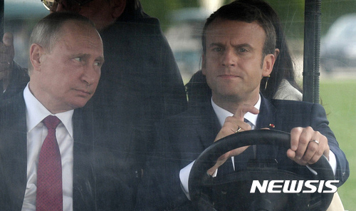 【파리=AP/뉴시스】에마뉘엘 마크롱 프랑스 대통령(오른쪽)과 블라디미르 푸틴 러시아 대통령이 29일(현지시간) 파리 베르사유 궁 정원에서 골프용 전기차를 타고 이동하고 있다. 2017.5.30.