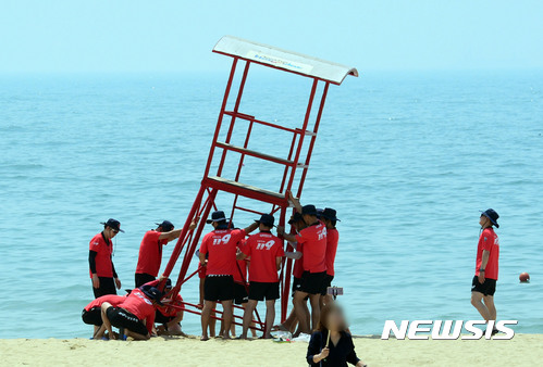 【부산=뉴시스】 하경민 기자 = 30일 부산 해운대해수욕장에서 119수상구조대원들이 해수욕장 개장을 앞두고 망루를 설치하고 있다. 부산소방안전본부는 소방대원 195명과 민간구조대 140여 명, 자원봉사자 300여 명, 의용소방대 1800여 명 등을 부산지역 해수욕장에 배치해 피서객 안전관리에 나선다. 해수욕장 개장 시기는 6월 1일 해운대·송정·송도, 7월 1일 광안리·다대포 등이다. 2017.05.30. yulnetphoto@newsis.com