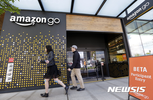 【시애틀(미 워싱턴주)=AP/뉴시스】지난 4월27일 미 워싱턴주 시애틀의 아마존고 매장 앞을 사람들이 지나가고 있다. 아마존 주가가 30일(현지시간) 주당 1000달러를 넘어섰다. 1997년 처음 상장된 아마존 주식은 20년 만에 그 가치가 638배에 이르게 됐다. 2017.5.31
