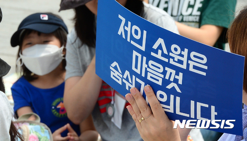 【서울=뉴시스】박주성 기자 = 31일 오전 서울 광화문광장에서 열린 미세먼지 대책 촉구 4차 선전전에 엄마를 따라온 어린이가 마스크를 쓰고 있다.&nbsp; 이날 미세먼지대책촉구카페는 중국발 미세먼지에 대한 근본적인 대책 마련과 국내 미세먼지 기준 강화를 촉구했다. 2017.05.31.&nbsp; park7691@newsis.com
