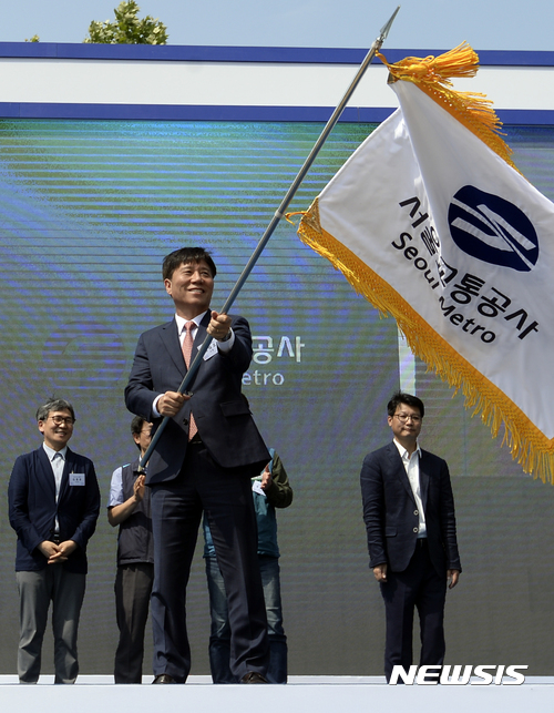 【서울=뉴시스】최진석 기자 = 김태호 서울교통공사 사장이 31일 서울 성동구 천호대로 서울교통공사에서 열린 서울교통공사 출범식에서 박원순 서울시장으로부터 건네받은 서울교통공사기를 흔들고 있다.&nbsp; 이날 서울메트로와 서울도시철도공사는 하나의 운영 기관인 서울교통공사로 23년 만에 통합 출범했다. 2017.05.31. myjs@newsis.com