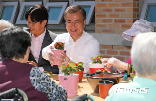 【서울=뉴시스】전진환 기자 = 문재인 대통령이 2일 오전 국가 치매책임제와 관련해 서울 강남구 국민건강보험 서울요양원을 방문해 텃밭공원에서 원예치료중인 치매환자, 영화배우 박철민씨와 화분을 만들고 있다. 2017.06.02. amin2@newsis.com