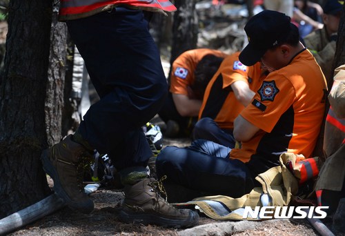 【서울=뉴시스】고승민 기자 = 수락산 화재 이틀째인 2일 오후 산 정상에서 지난 새벽부터 고된 진화 작업을 마친 소방관이 잠시 모자란 수면을 청하고 있다.&nbsp; 불은 최초 신고 후 약 14시간만인 이날 오전 10시52분께 공식 진화됐으며 소방당국은 숨은 불씨를 찾아 제거하는 등 비상감시체계에 돌입했다.&nbsp; 화재는 야간 등산객 또는 주변 무속인의 부주의로 인해 발생했을 것으로 추정되고 있으며, 소방당국은 현재 육안감식을 통해 정확한 원인을 조사하고 있다. 2017.06.02.&nbsp; kkssmm99@newsis.com