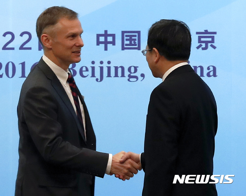  【베이징=AP/뉴시스】중국 주재 미국 대사대리 데이비드 랭크가 도널드 트럼프 대통령의 파리 기후변화협정 탈퇴를 반대하며 사임한 데 대해 6일 중국 외교부가 "해당 사건은 미중 협력관계 영향을 주지 않을 것"이라고 밝혔다.&nbsp; 지난해 11월 21일 랭크 전 대사대리(왼쪽)가 베이징에서 열린 한 행사에서 쉬훙 중국 외교부 조약법률사 사장과 악수하는 모습. 2017.06.06