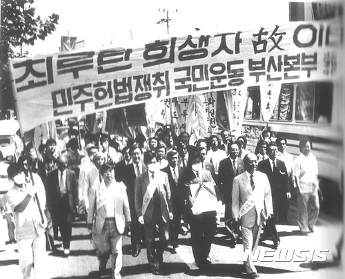 【서울=뉴시스】 1987년 6월27일 낮 11시30분 부산 범일성당에서 장례미사를 마친 뒤 당시 노무현 변호사가 고 이태춘씨의 영정을 들고 문재인 변호사와 함께 행진하는 모습. (사진출처: 노무현재단) 2017.06.08