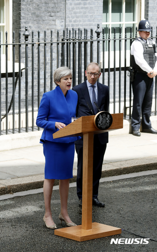 【런던=AP/뉴시스】 테리사 메이 영국 총리가 총선 다음날인 9일 여왕에게 정부구성안을 보고한 뒤 총리 관저로 돌아와 북아일랜드 민주통합당과의 연정 방침을 기자들에게 말하고 있다. 옆에 선 총리의 남편 필립도 버킹엄궁 예방에 동반했다. 2017. 6. 9.&nbsp;&nbsp; 