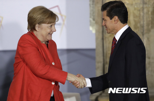 【멕시코시티=AP/뉴시스】앙겔라 메르켈 독일 총리와 엔리케 페냐 니에토 멕시코 대통령이 10일(현지시간) 멕시코 수도 멕시코시티에서 열린 멕시코 기업인들과의 회담에서 악수를 나누고 있다. 2017.06.11.