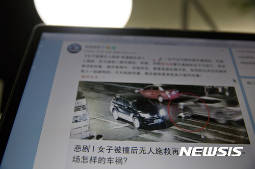 【베이징=AP/뉴시스】지난 10일 중국 허난(河南)성 주마뎬(駐馬店)의 한 도로에서 여성 한 명이 차에 치이는 교통사고를 당한 뒤 아무 도움도 받지 못한 채 방치돼 2차 사고로 숨지는 모습이 중국 소셜미디어를 뜨겁게 달구며 파문을 일으키고 있다. 이 장면을 본 중국 네티즌들은 사고를 당한 여성을 외면한 많은 행인들과 자동차 운전자들에 대해 분노를 터트렸다. 사진 아래에 한자로 "어떻게 이런 비극이 일어날 수 있느냐"고 개탄하는 글이 붙어 있다. 2017.6.12