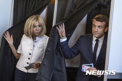 【르투케=AP/뉴시스】에마뉘엘 마크롱 대통령 부부가 11일 총선 1차 투표일에 사저가 있는 프랑스 북부 휴양지의 투표소에서 각자 기표를 마치고 동시에 밖으로 나오고 있다. 대통령 부부는 파리 엘리제궁에 살고 있다. 2017. 6. 11.