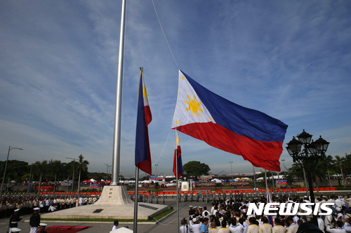 【마닐라=AP/뉴시스】제119회 독립기념일을 맞은 필리핀에서 12일(현지시간) 기념식이 열리는 마닐라 리살공원에 필리핀 국기가 올라가고 있다. 2017.06.12