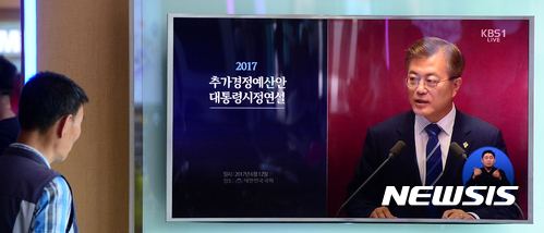 【서울=뉴시스】박주성 기자 = 문재인 대통령이 국회에서 11조 2천억 원 규모의 일자리 추경 예산안 처리와 관런해 첫 시정연설을 하는 12일 오후 서울 용산구 서울역 대합실에서 시민들이 TV로 문재인 대통령의 시정연설을 시청하고 있다. 2017.06.12. park7691@newsis.com