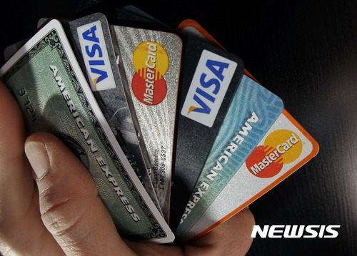 【노스앤도버(미 매사추세츠주)=AP/뉴시스】지난 2분기 말(6월30일) 현재 미국의 가계부채가 12조8000억 달러로 2009년 이래 최고를 기록했다고 월 스트리트 저널(WSJ)이 15일 보도했다. 사진은 지난 2012년 3월5일 미 매사추세츠주 노스앤도버에서 한 남성이 신용카드를 들어보이고 있는 모습. 2017.8.16