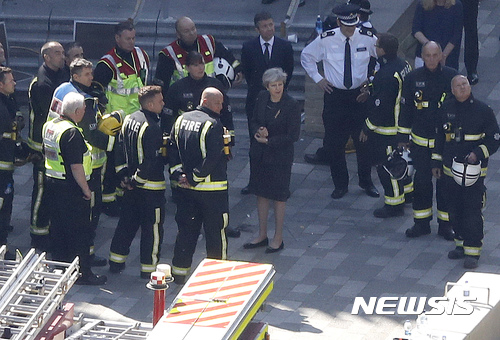 【런던=AP/뉴시스】테리사 메이 영국 총리가 15일(현지시간) 런던 아파트 화재현장을 찾아 소방관들과 대화하고 있다. 2017.06.16