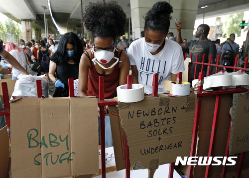 【런던=AP/뉴시스】영국 시민들이 15일(현지시간) 런던에서 고층 아파트 화재로 집을 잃은 주민들에게 나눠 줄 구호품을 정리하고 있다. 지난 14일 그레펠타워에서 발생한 화재로 수많은 인명피해가 발생해 제기된 건물 안전 문제가 사회갈등으로 번지고 있다. 2017.06.16 