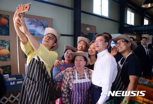 [제주=뉴시스]전신 기자 = 문재인 대통령이 2017년 6월 16일 제주 서귀포시에 위치한 제주도 농수산물 전문업체 무릉외갓집에서 직원들과 기념촬영을 하고 있다. 2020.05.10. photo1006@newsis.com